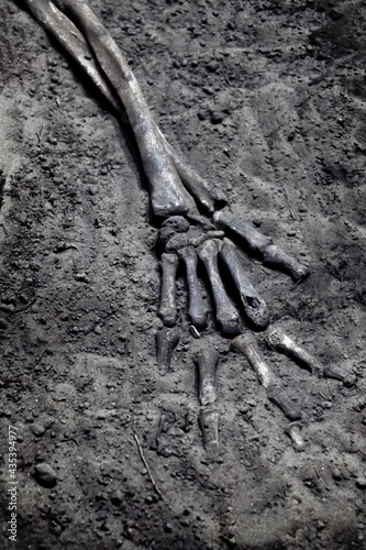 a skeleton's hand in a grave close-up. Ancient burial site of Tagar culture, symbol of death, blurr, soft focus background