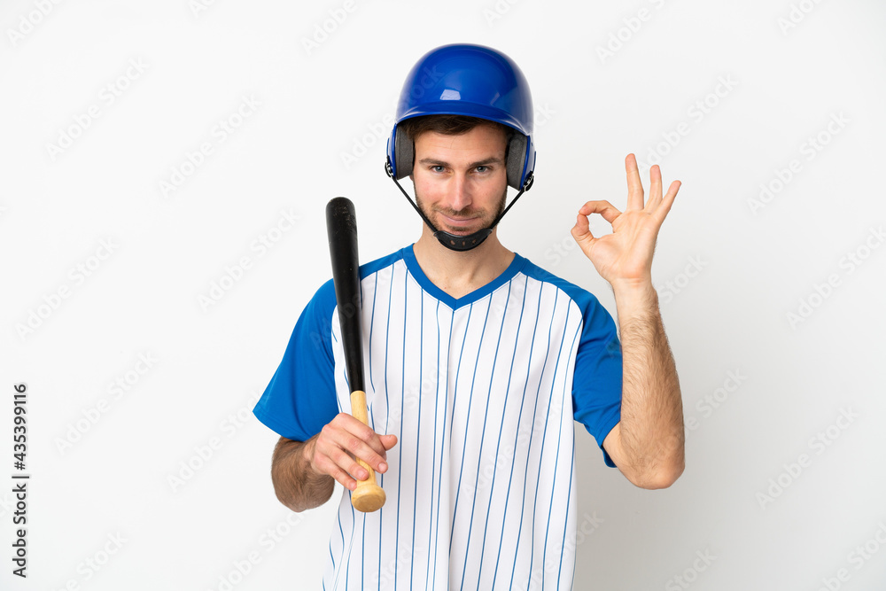 Young caucasian man playing baseball isolated on white background showing ok sign with fingers Young caucasian man playing baseball isolated on white background showing ok sign with fingers