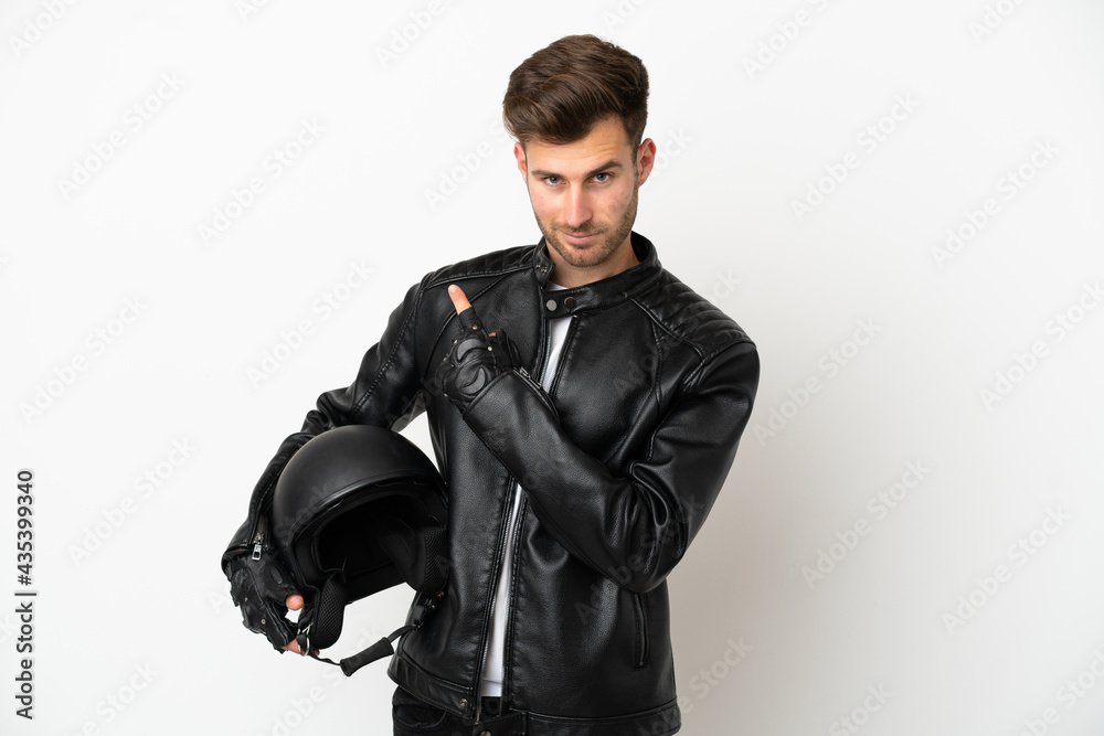 Young caucasian man with a motorcycle helmet isolated on white background pointing to the side to present a product Young caucasian man with a motorcycle helmet isolated on white background pointing to the side to present a product