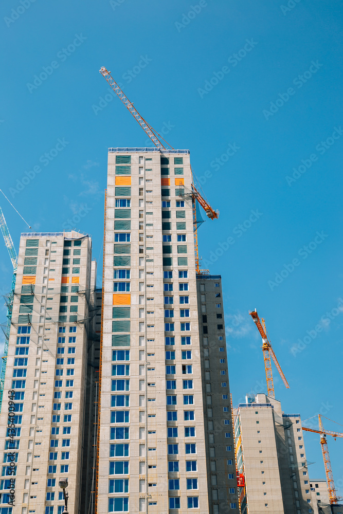 Modern apartment building with crane on construction site Modern apartment building with crane on construction site