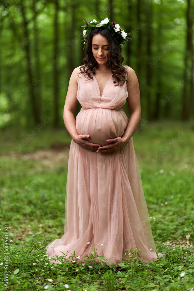 Beautiful latino pregnant woman in the forest