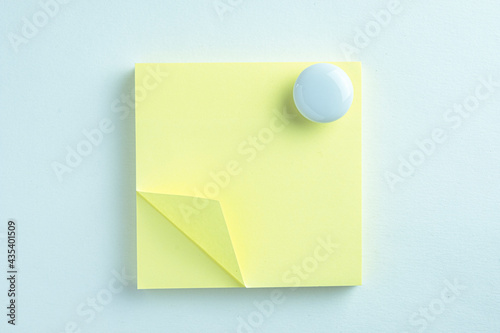 Blank Yellow sticky note block with magnet clip over white wall background.,clipping path.