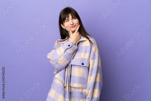 Young Ukrainian woman isolated on purple background having doubts
