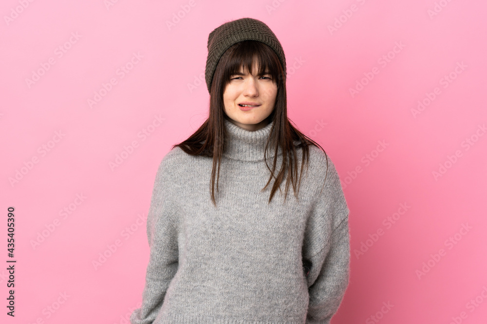Teenager Ukrainian girl with winter hat isolated on white background having doubts and with confuse face expression Teenager Ukrainian girl with winter hat isolated on white background having doubts and with confuse face expression