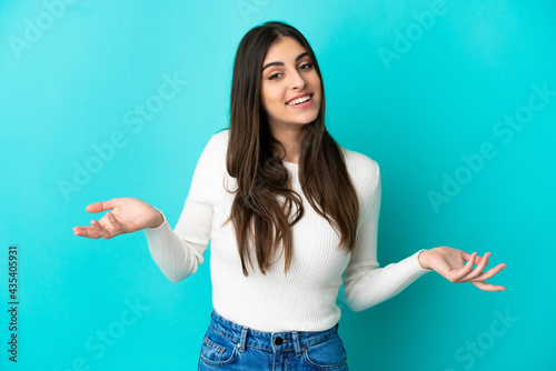 Young caucasian woman isolated on blue background happy and smiling