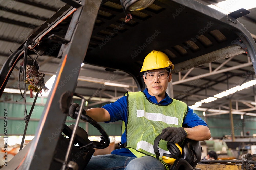 Fototapeta premium Asian factory male worker driving and marking operating on forklift truck in the industry factory