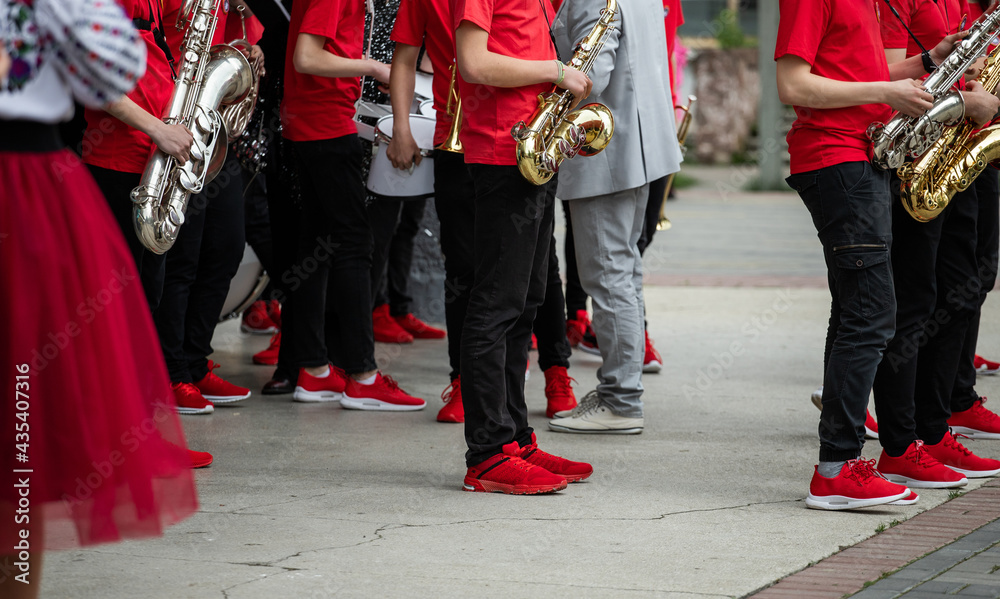 group of musicians, orchestra in red t-shirts and sneakers playing the saxophone group of musicians, orchestra in red t-shirts and sneakers playing the saxophone