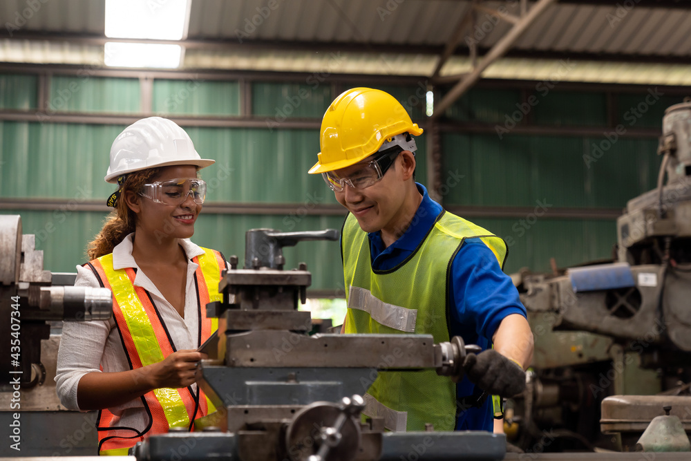 Group of male and female worker maintenance machine in industry factory. Technician worker working, repair machine lathe metal in the industry factory Group of male and female worker maintenance machine in industry factory. Technician worker working, repair machine lathe metal in the industry factory