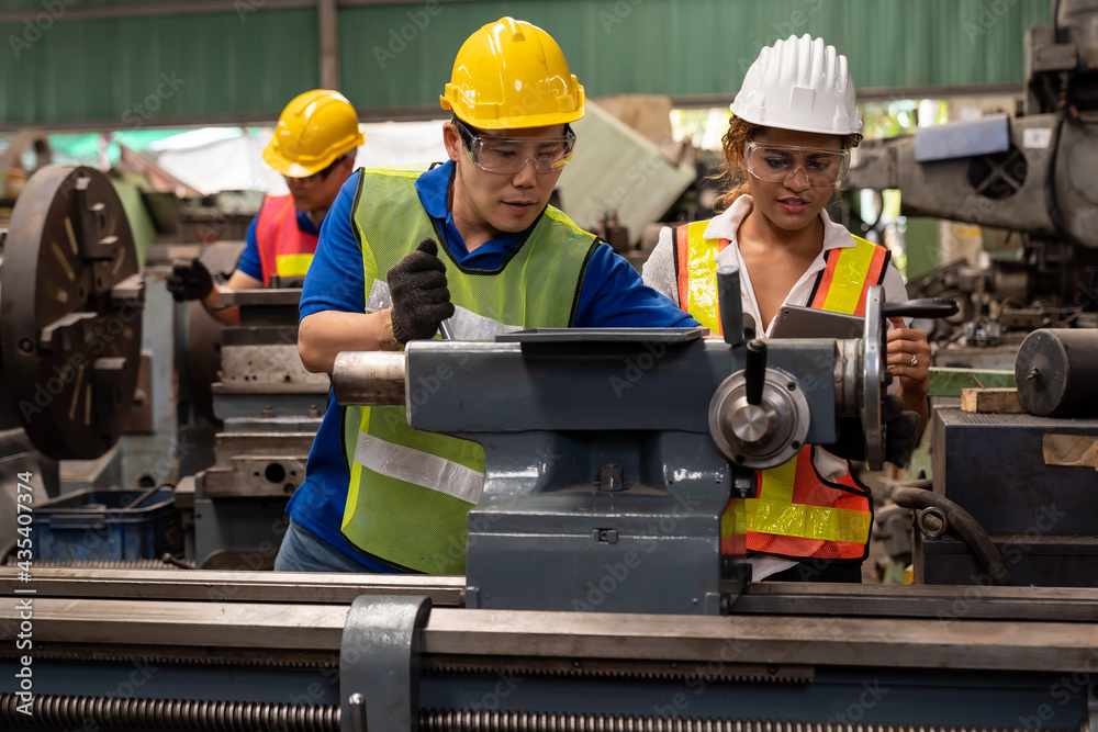 Group of male and female worker maintenance machine in industry factory. Technician worker working, repair machine lathe metal in the industry factory Group of male and female worker maintenance machine in industry factory. Technician worker working, repair machine lathe metal in the industry factory