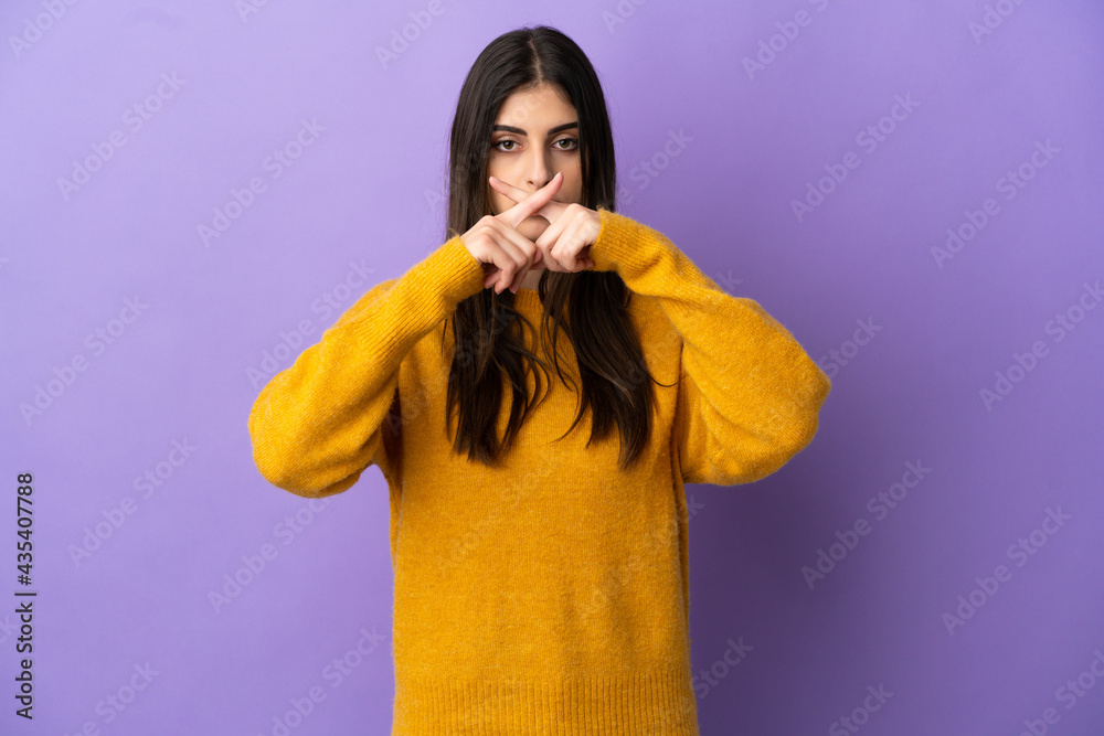 Young caucasian woman isolated on purple background showing a sign of silence gesture Young caucasian woman isolated on purple background showing a sign of silence gesture