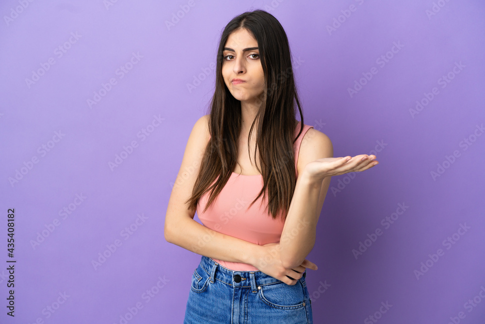 Young caucasian woman isolated on purple background having doubts