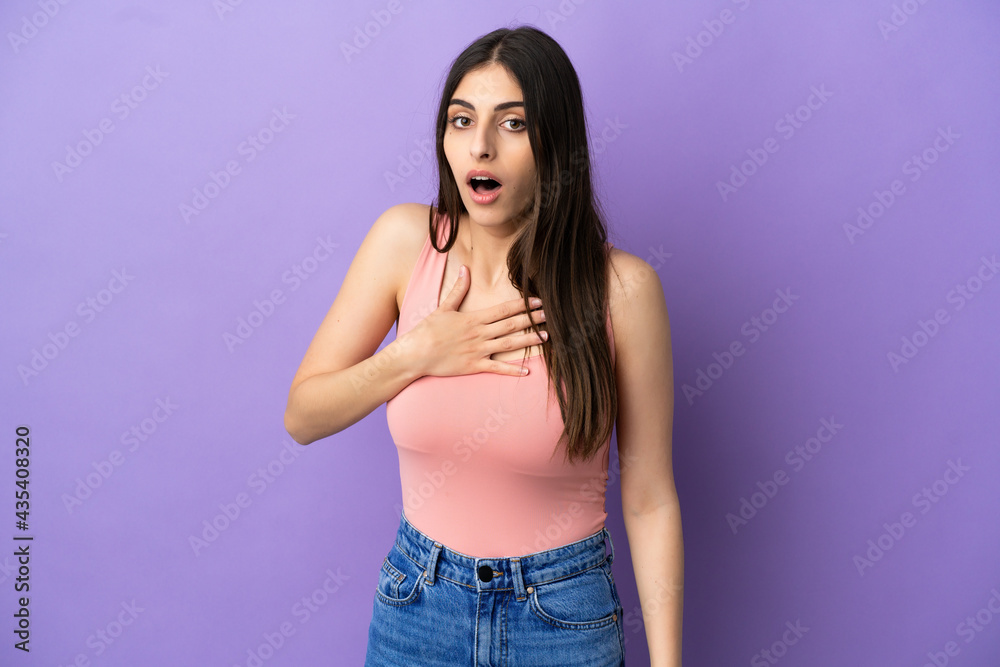Young caucasian woman isolated on purple background surprised and shocked while looking right Young caucasian woman isolated on purple background surprised and shocked while looking right
