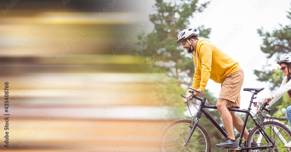 Obraz premium Composition of people riding bicycle in forest with motion blur