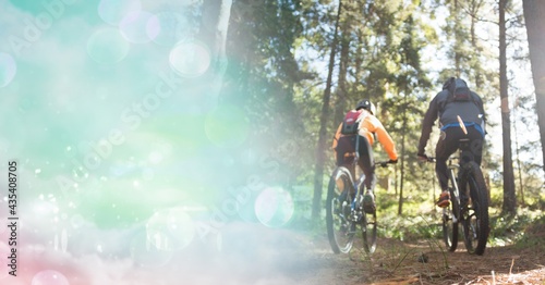 Fototapeta Naklejka Na Ścianę i Meble -  Composition of people riding bicycle in forest with blur