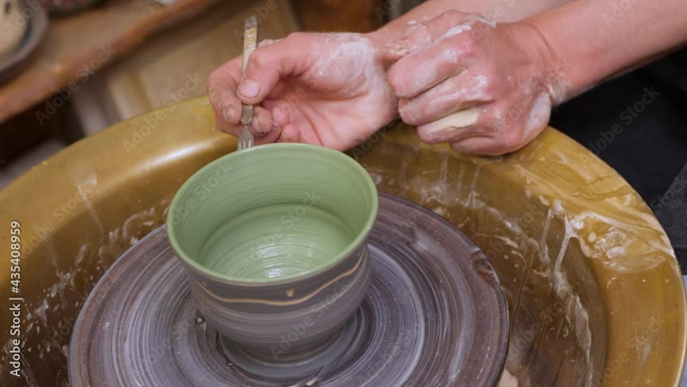 Pottery painting on clay pot. Handmade workshop ceramic. Earthenware. Painting ceramic pot with paint brush in pottery class potter workshop wheel. Potter work hands close up painting pottery making Pottery painting on clay pot. Handmade workshop ceramic. Earthenware. Painting ceramic pot with paint brush in pottery class potter workshop wheel. Potter work hands close up painting pottery making