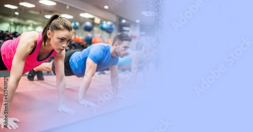 Composition of fit caucasian woman and man doing press ups in gym with blue blur