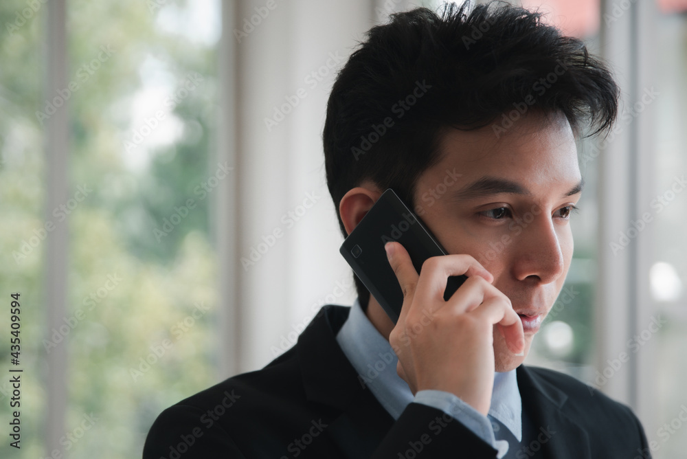 A handsome young businessman using smartphone in the office. A handsome young businessman using smartphone in the office.