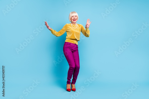 Full body photo of funky short hairdo senior lady dance wear blouse pants isolated on blue color background