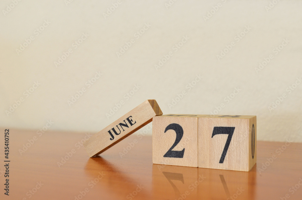 June 27, Date design with calendar cube on wooden table and white background.
June 27, Date design with calendar cube on wooden table and white background.