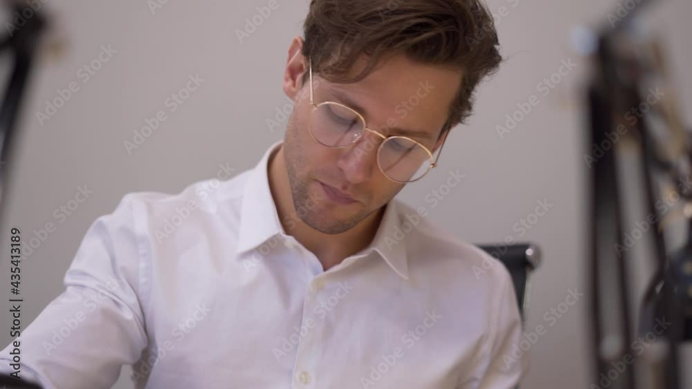Zoom in on Caucasian businessman in classic spectacles for provide eyes protection analyzing paperwork reports during office productivity, confident male manager checking documents at table desktop Zoom in on Caucasian businessman in classic spectacles for provide eyes protection analyzing paperwork reports during office productivity, confident male manager checking documents at table desktop