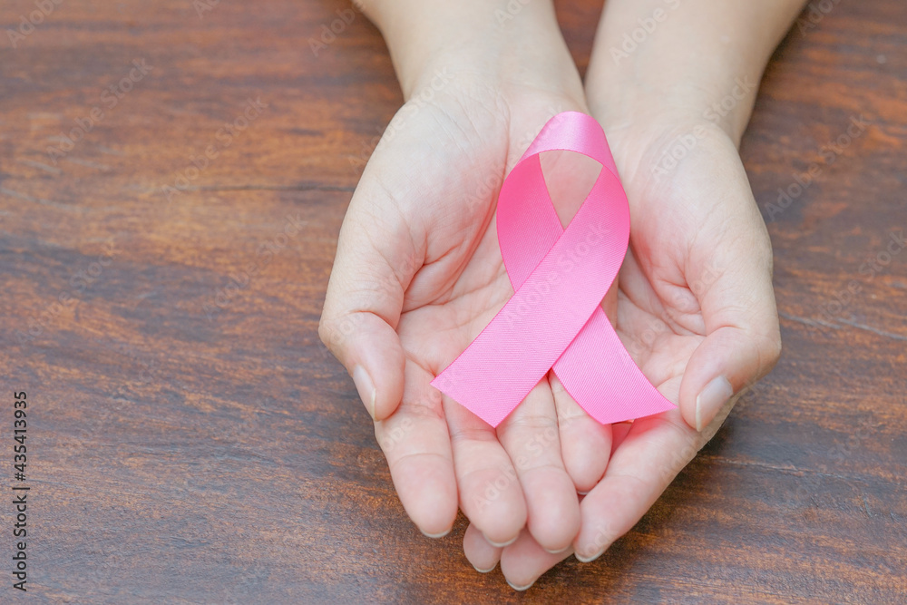 woman supporting pink ribbon in hands,october breast cancer awareness month, World cancer day concept, selective focus woman supporting pink ribbon in hands,october breast cancer awareness month, World cancer day concept, selective focus