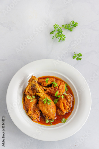 North Indian Chicken Curry with Rice Garnished with Cilantro Directly Above Vertical Photo
