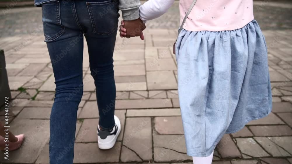 Happy family walking towards the park. Blue jeans, blue skirt, white shoes. Happy family walking towards the park. Blue jeans, blue skirt, white shoes.