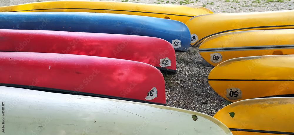 Plastic canoes in row without paddles as a summer camp concept Plastic canoes in row without paddles as a summer camp concept