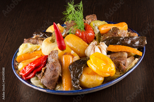 large chunks of stew with whole vegetable stew. peppers, carrots, eggplant, tomatoes, onions, potatoes in big dish