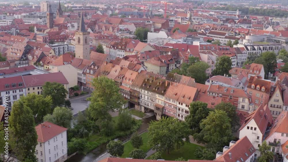 Aerial Panning The Historic Merchants Bridge And River In The Heart Of Old Erfurt, With Steep Rooftops, Timber Framed Homes, Narrow Streets, And Lush Green Trees Aerial Panning The Historic Merchants Bridge And River In The Heart Of Old Erfurt, With Steep Rooftops, Timber Framed Homes, Narrow Streets, And Lush Green Trees