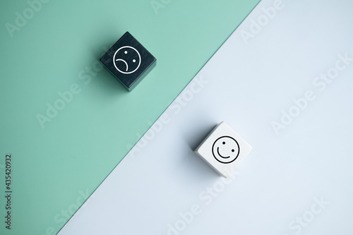 Foto Smiley face and blurred sad face icon on wood cube