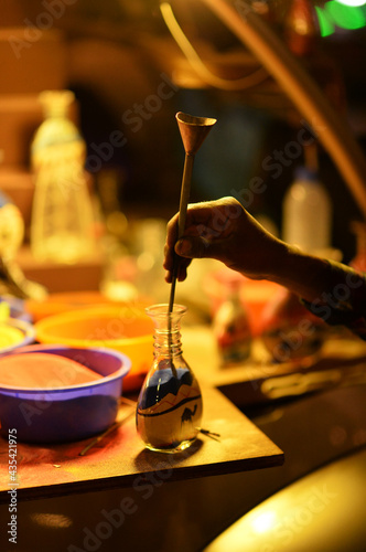 person making souvenir from sand