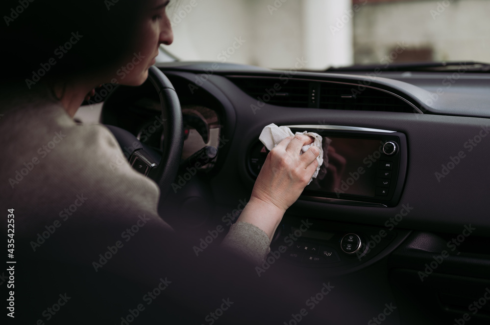 Female driver taking care of car interior hygiene. Woman's hand