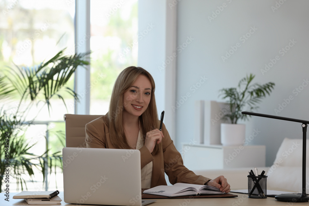 Secretary working at wooden table in office Secretary working at wooden table in office