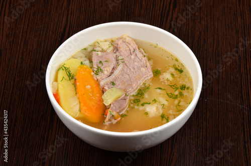 soup with meat, potatoes, carrots and herbs