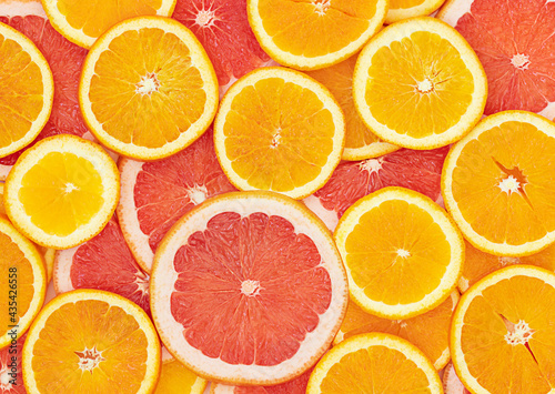 Bright summer background with slices of oranges and grapefruits 