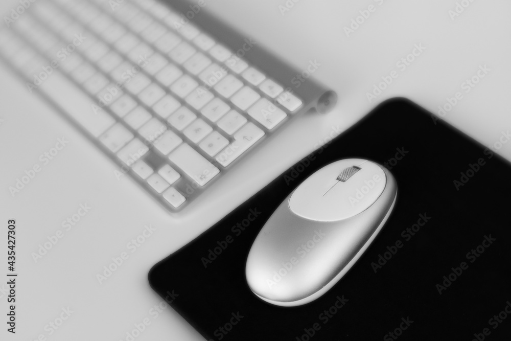 Computer keyboard with mouse and mousepad on white background. Black & white photo. Computer keyboard with mouse and mousepad on white background. Black & white photo.
