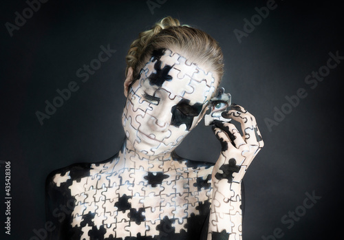 Konstfotografi Mit Puzzlemuster bemalte Frau hält sich den Kopf mit einem Puzzleteil bei geschl