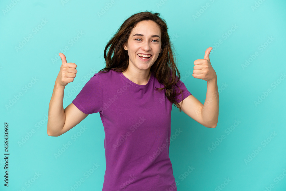 Young caucasian woman isolated on blue background giving a thumbs up gesture Young caucasian woman isolated on blue background giving a thumbs up gesture