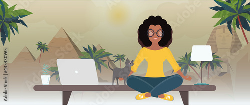 The girl sits at the office table and dreams of Egypt. Office overlooking the desert. The concept of rest while working.