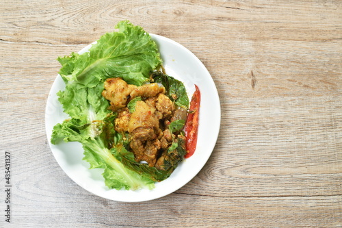 spicy fried chicken with chili and herb on lettuce in plate