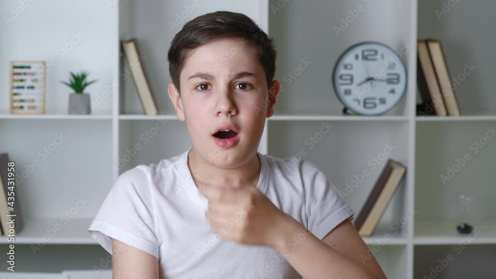 Portrait of scared boy shocked by terrible scene, afraid teenager look at camera, cover mouth with his hand at home. Portrait of scared boy shocked by terrible scene, afraid teenager look at camera, cover mouth with his hand at home.