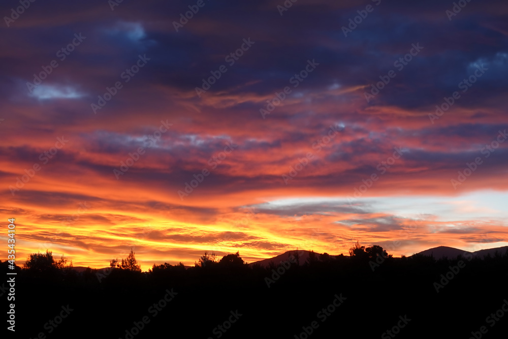 cloudy sky sunset over dark landscape