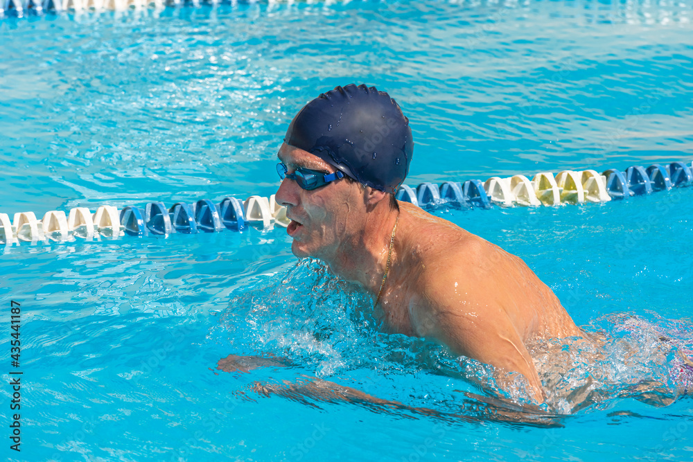 an adult, former swimmer, trains in a public swimming pool