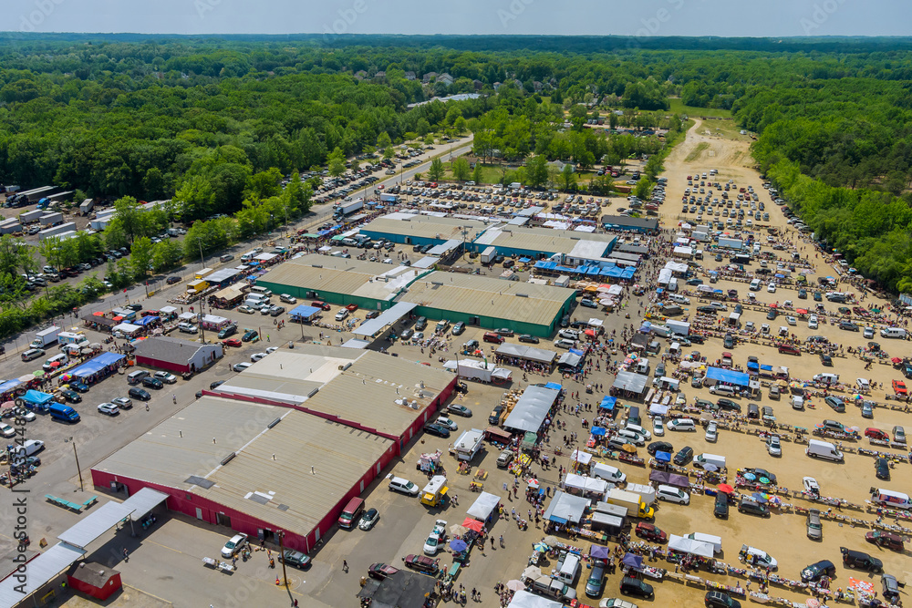 Panorama view on flea market roof top with miscellaneous items and crowds of buyers and sellers in Englishtown NJ USA