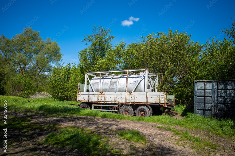  large white water tank stands on a trailer at the edge of a field