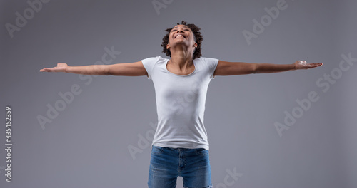 Gleeful exuberant young Black woman holding out her arms