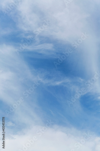 Blue cloudy sky on a clear sunny day. Background. Space for text. Vertical.