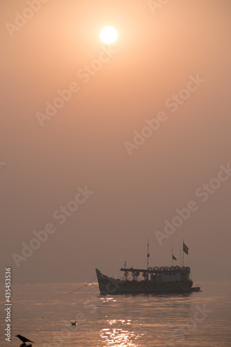 Sihouette of boat sailing in sunset in Mumbai beach at killeshwar temple at madh photo