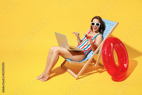 Tableau sur toile Full body length happy young woman wear red blue one-piece swimsuit sit on chair
